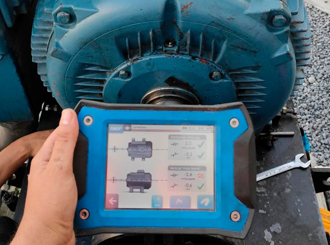 Dispositivo de alineación láser SKF realizando medición de precisión en motor eléctrico industrial.